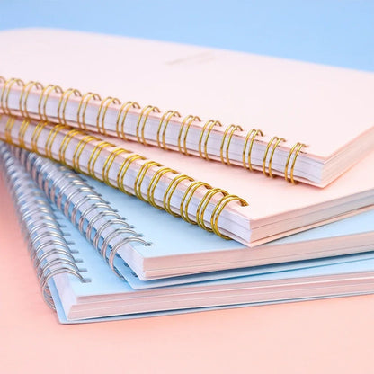 Notepads stacked on top of each other, the top are pink and the bottom blue.